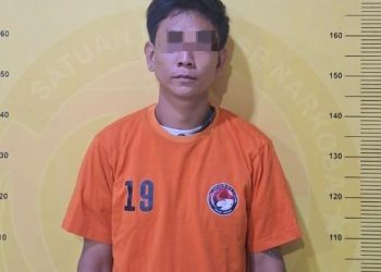 Tersangka saat di kantor polisi.