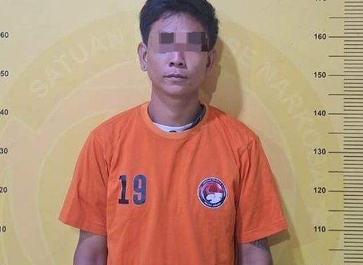 Tersangka saat di kantor polisi.