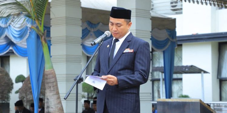 Hendri Yanto Sitorus membacakan amanat Mendikdasmen pada upacara peringatan Hari Guru. 