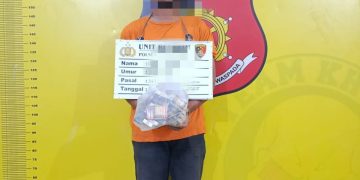 Tersangka saat di kantor polisi.