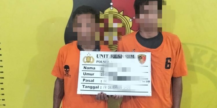 Kedua tersangka saat di kantor polisi.