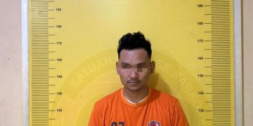 Tersangka saat di kantor polisi.