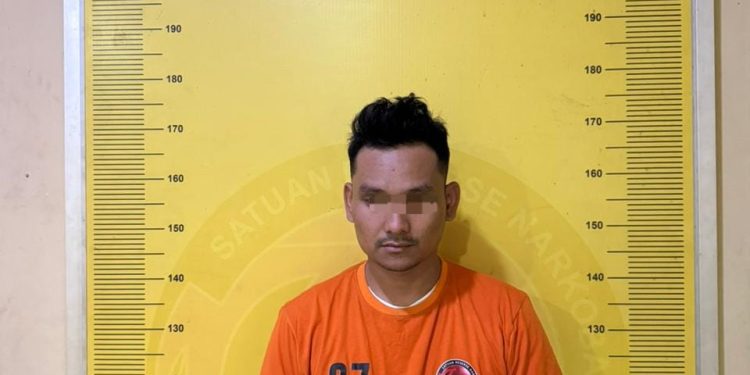 Tersangka saat di kantor polisi.