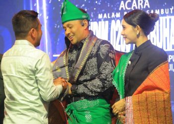 H . Samsul Tanjung menyerahkan kain songket kepada Letnan Kolonel Kav Hanung Kaptiaj.
