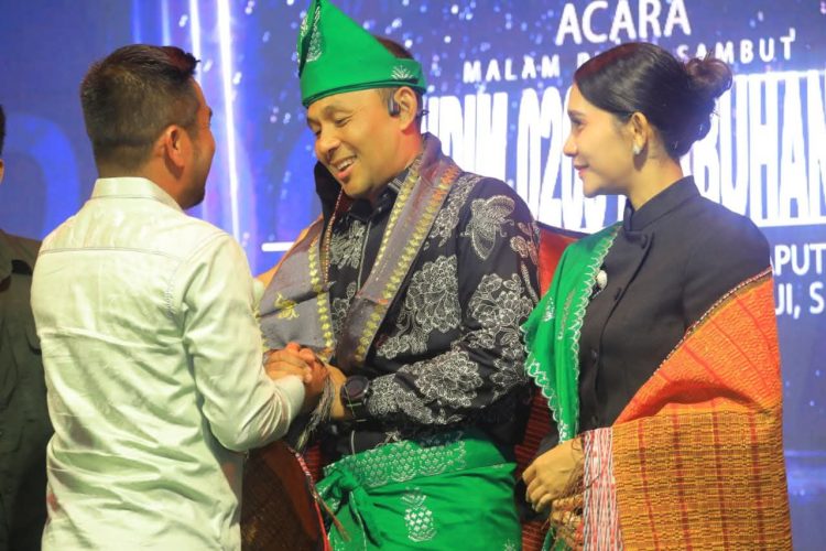 H . Samsul Tanjung menyerahkan kain songket kepada Letnan Kolonel Kav Hanung Kaptiaj.