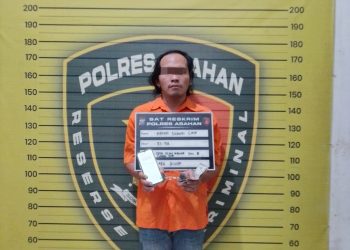 Tersangka saat di kantor polisi.