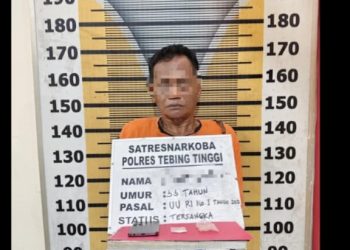 Tersangka saat di kantor polisi.