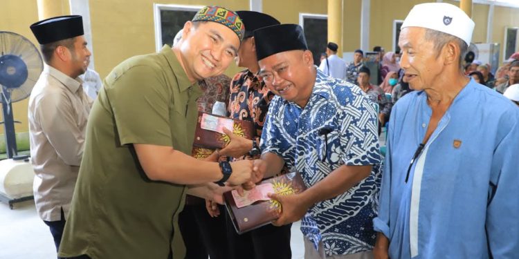 Bupati Labuhanbatu Utara, Hendri Yanto Sitorus, menyerahkan tali asih guru magrib mengaji, bilal mayit, dan nazir masjid 