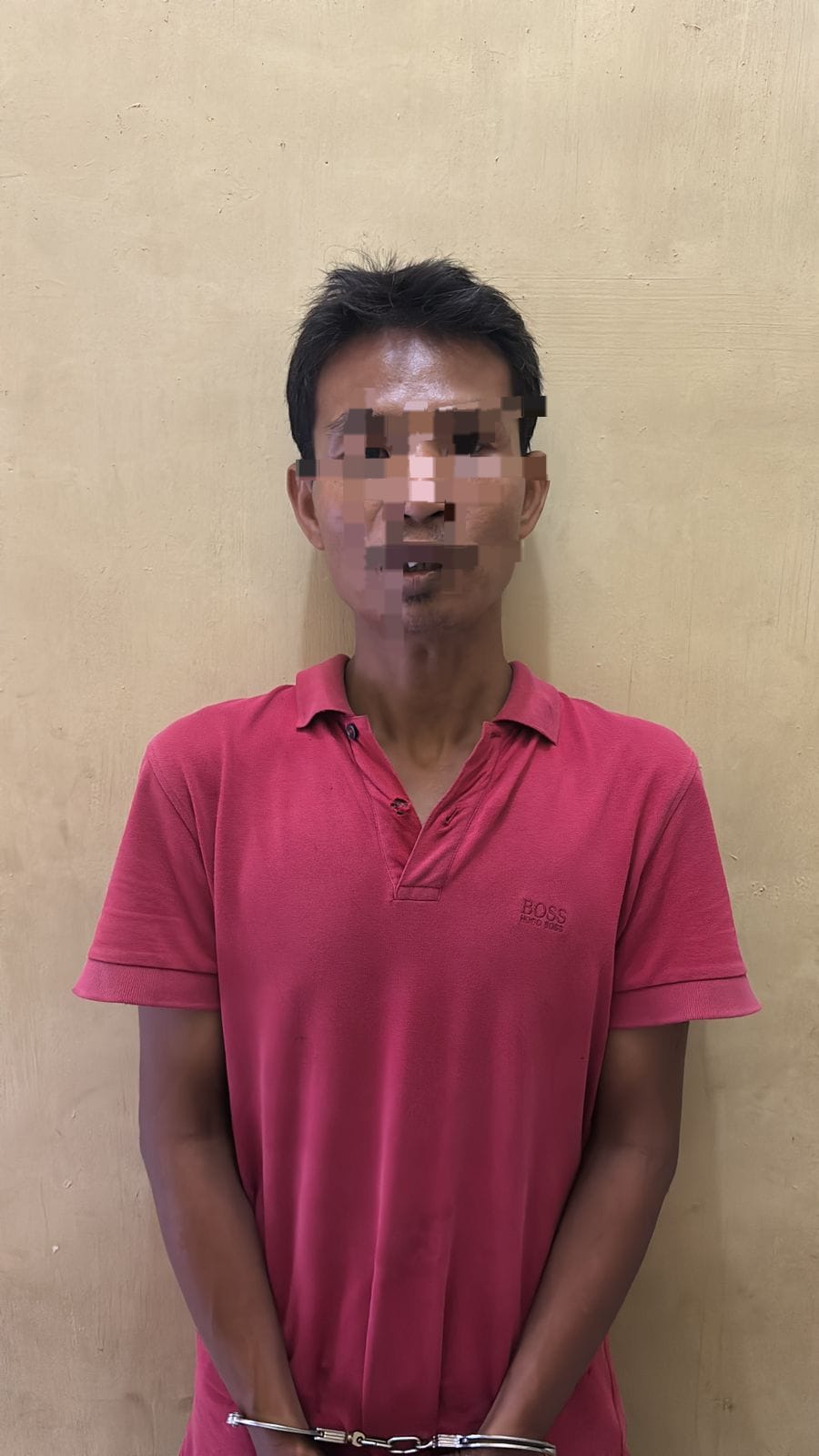 Tersangka saat berada di kantor polisi. 