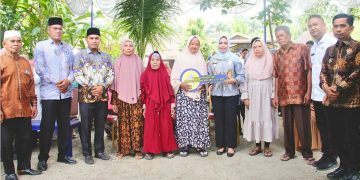 Bupati Labuhanbatu dr Hj Maya Hasmita saat menyerahkan kunci rumah secara simbolis kepada warga yang mendapatkan bantuan program renovasi rumah dari pemerintah. 