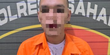 Tersangka saat di kantor polisi.