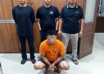 Tersangka saat di kantor polisi.