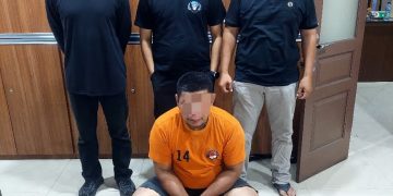 Tersangka saat di kantor polisi.