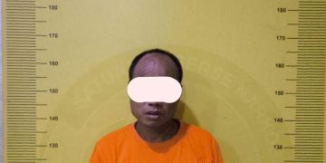 Tersangka saat di kantor polisi.