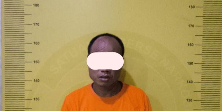 Tersangka saat di kantor polisi.