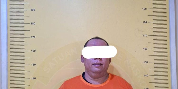 Tersangka saat di kantor polisi.