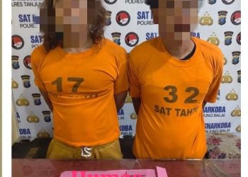 Kedua tersangka saat di kantor polisi.