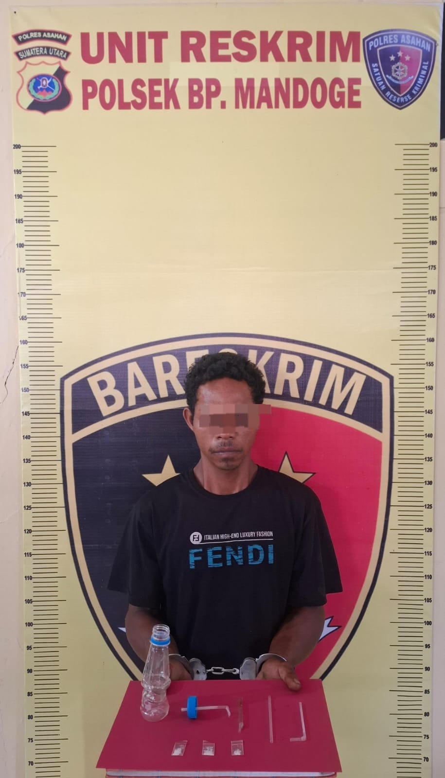 Tersangka saat di kantor polisi.