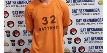 Tersangka saat di kantor polisi.