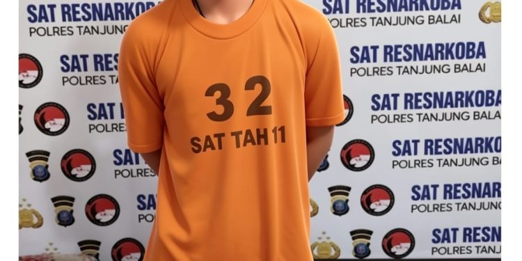 Tersangka saat di kantor polisi.