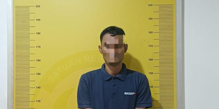 Tersangka saat di kantor polisi.