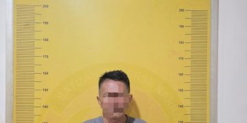 Tersangka saat di kantor polisi.