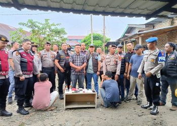 Dua tersangka saat diamankan polisi di TKP. 