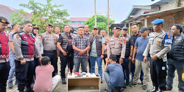 Dua tersangka saat diamankan polisi di TKP. 